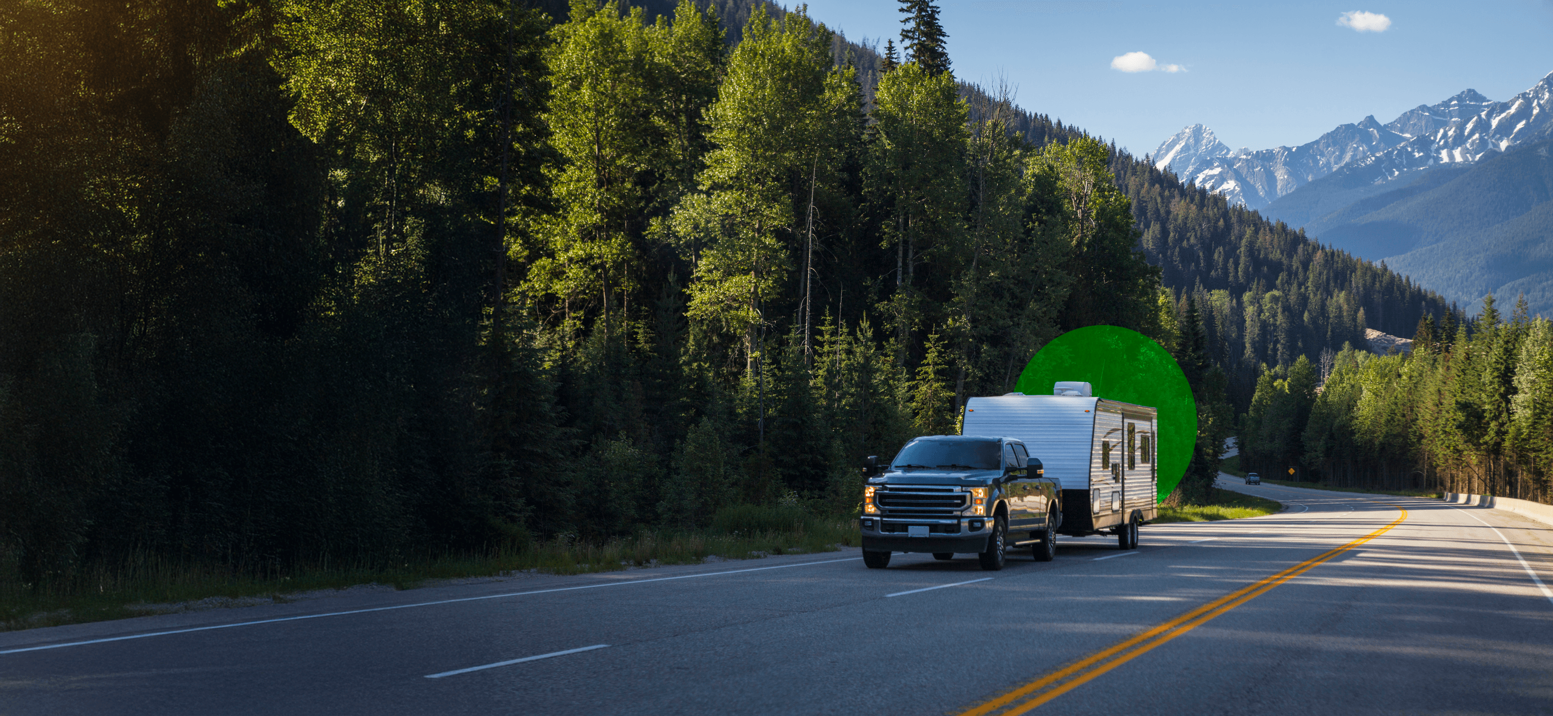 RV parked by serene lake with mountains in background at sunset