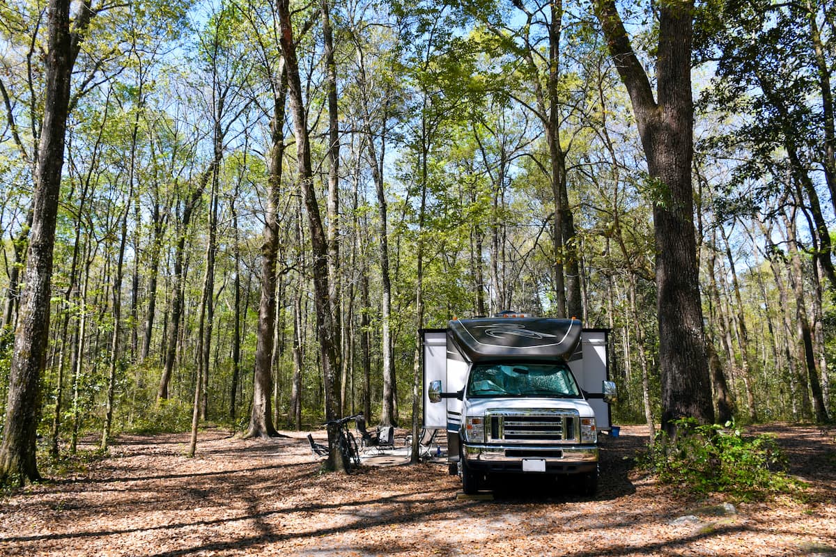 Modern camper van with pop-up roof parked on mountain road with scenic backdrop