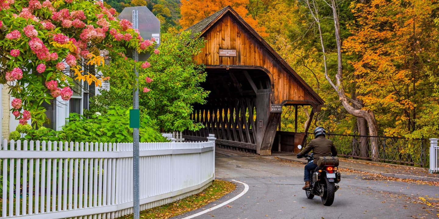 Motorcycle rider near a covered bridge in Vermont