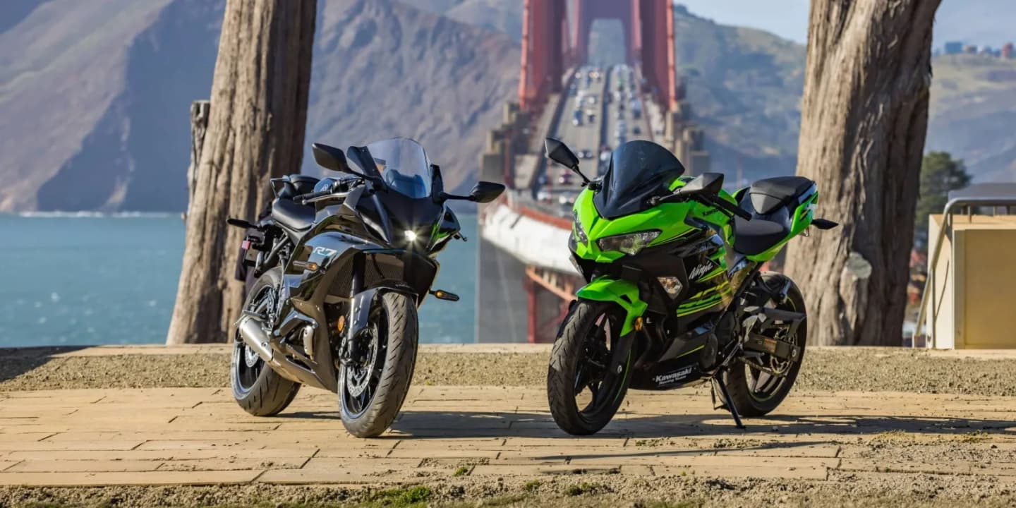 Black Yamaha R7 and green Kawasaki Ninja sport bikes parked near the Golden Gate Bridge