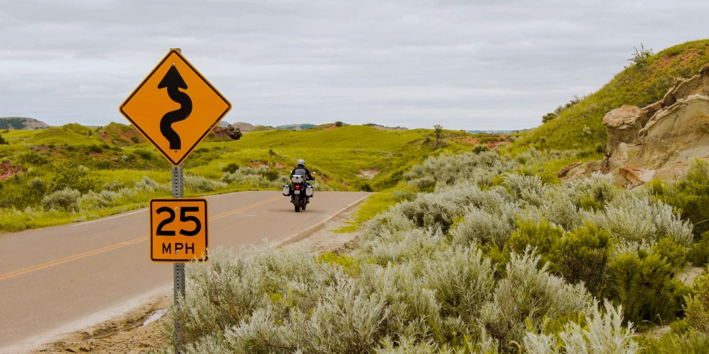 Motorcycle rider traveling along a rural road in North Dakota
