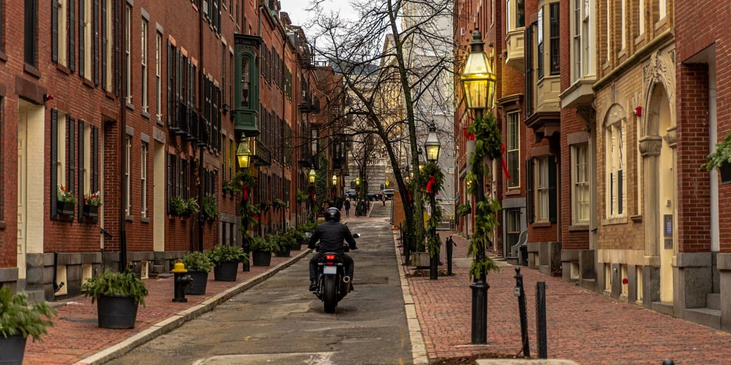 Motorcycle rider traveling through a historic street in Massachusetts
