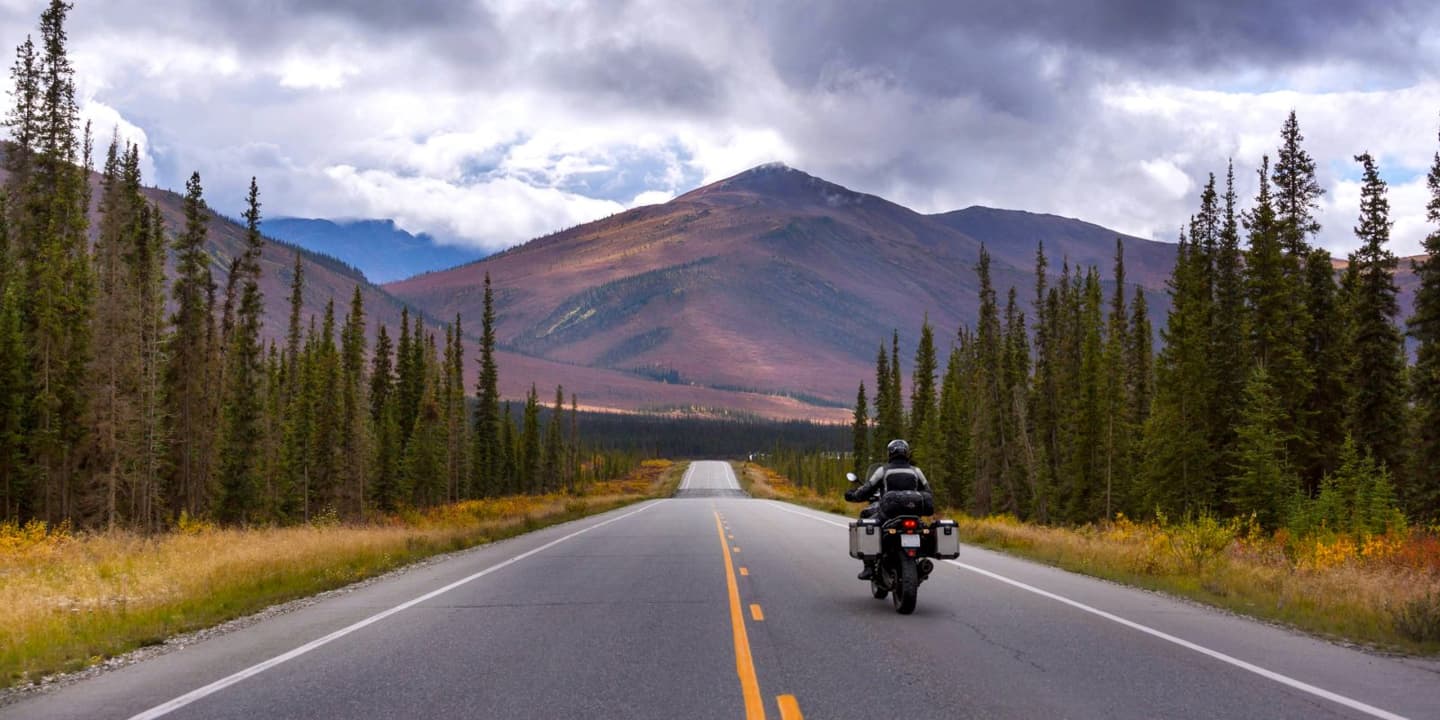 Motorcycle rider traveling through the scenic Alaska wilderness