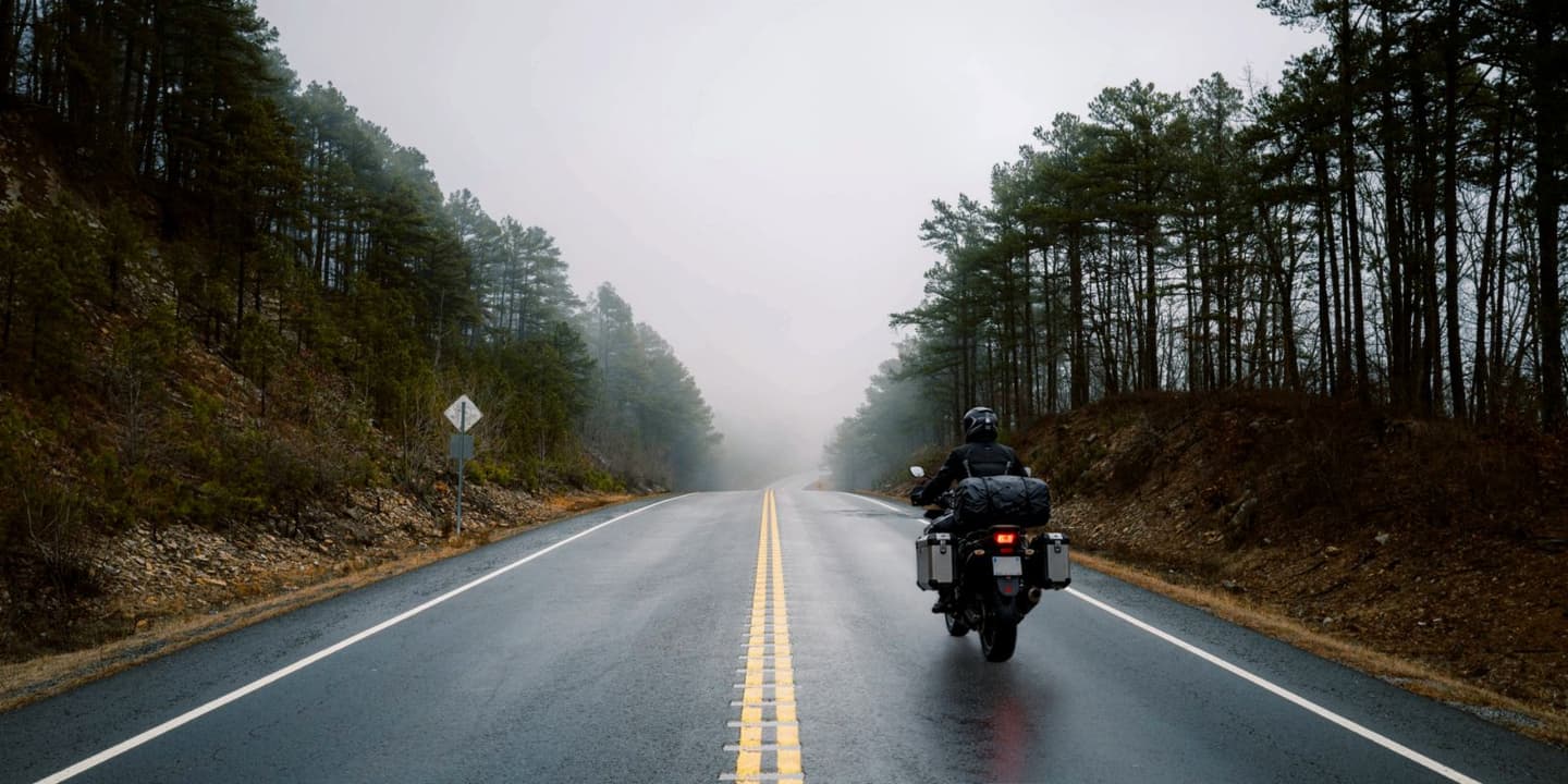 Motorcycle rider traveling through a foggy road in Arkansas