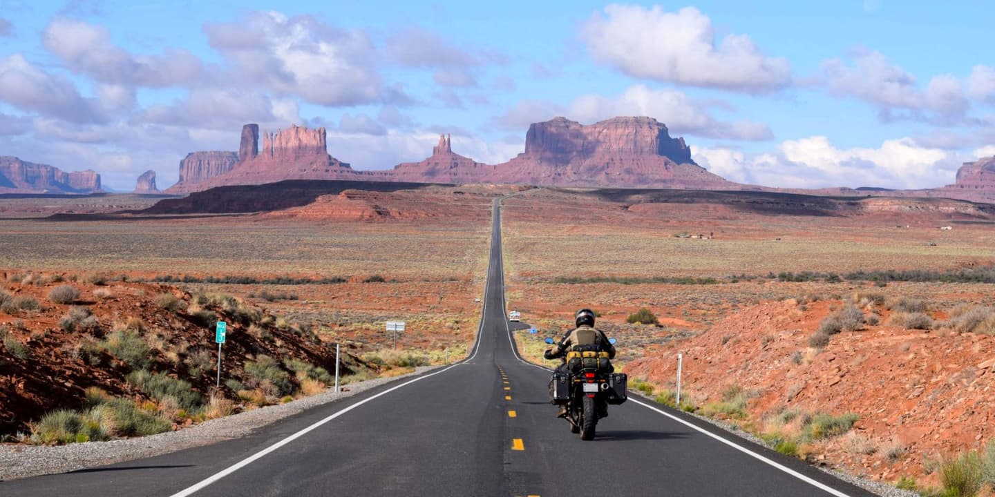 Motorcycle rider traveling through Utah's red rock landscape