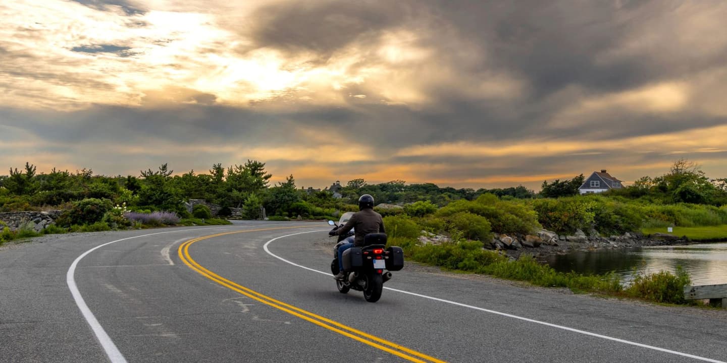 Motorcycle rider traveling along a scenic road in Rhode Island
