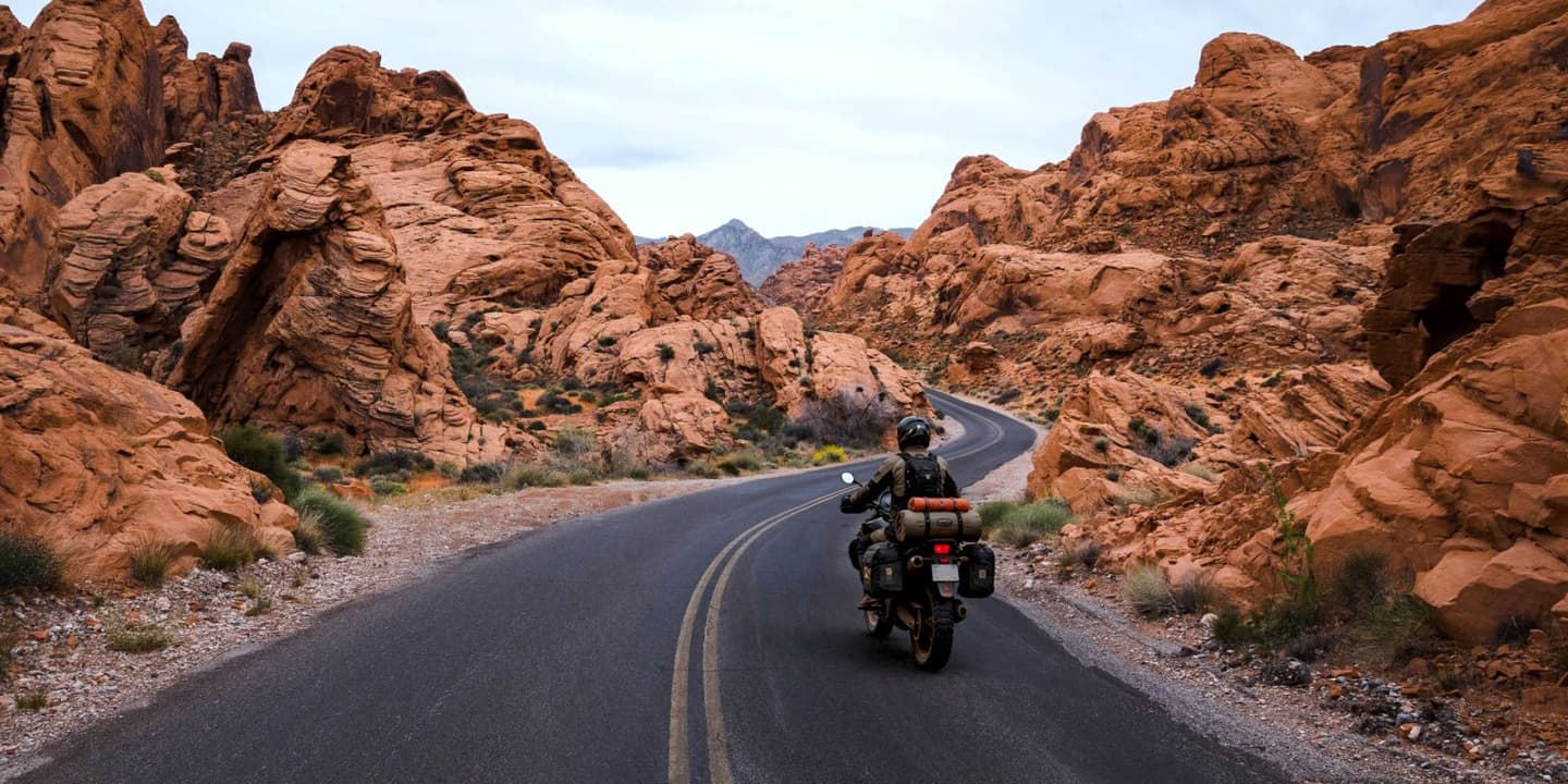 Motorcycle rider traveling through the desert landscape of Nevada